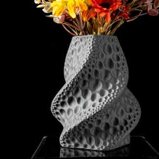 Vase with unique bubble-textured design holding colorful flowers on black background.