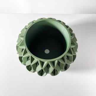 Close-up of a green 3D-printed turbine component with intricate geometric details.