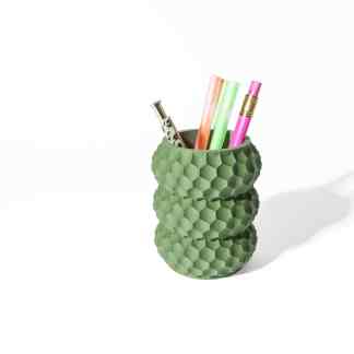 3D printed green textured honeycomb pen holder with colorful pens and markers on white background.