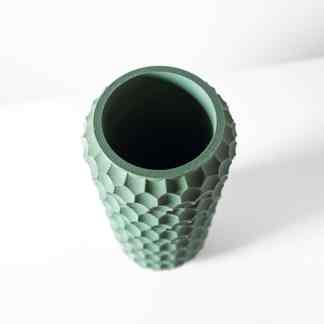 Close-up of textured, ergonomic golf club grip with hexagonal pattern, 3D printed in mint green color, on white background for sports equipment manufacturing.