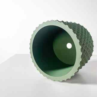 Close-up of a custom 3D-printed green pipe fitting with textured grip surface, showcasing advanced additive manufacturing technology.