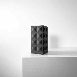 Sleek black 3D printed geometric sculpture displayed on white pedestal, perfect for modern interior design.