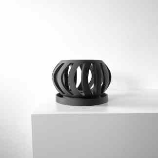 Modern black 3D printed lamp on white table.