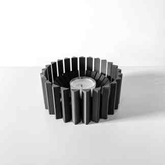 Elegant black metal candle holder with a tea light candle, ideal for stylish home accents.