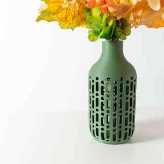 Vase with artificial green, yellow, and orange leaves, stylish home decor piece, modern interior accessory.