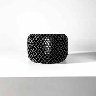 Sleek black cylindrical 3D printed mesh decor piece on a white surface, minimalist style.