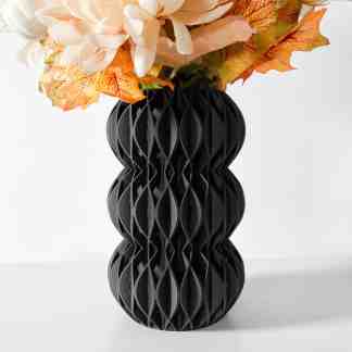 Vase image showing intricate black 3D printed design with autumn leaves and flowers.