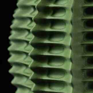 Close-up of a green 3D-printed structure showcasing detailed lines and precise layering.