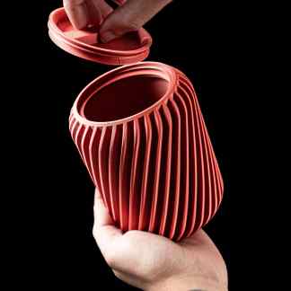 Red 3D-printed vase with ribbed pattern, perfect for contemporary interior decoration.
