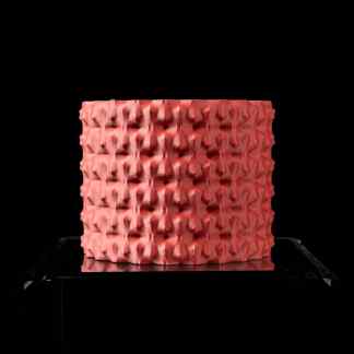 Vibrant pink 3D printed textured cube showcasing intricate surface patterns, perfect for modern art displays.