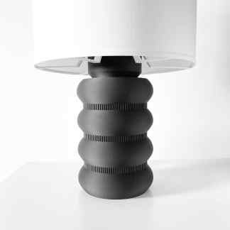 Stylish black and white table lamp with sculptural base, ideal for modern home decor and ambient lighting.