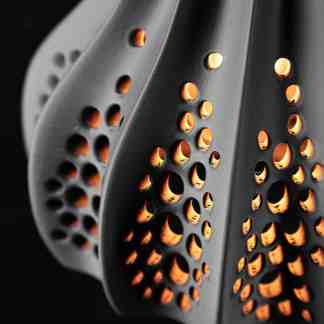 Close-up of a high-precision 3D printed turbine blade showcasing intricate perforations and surface detail.