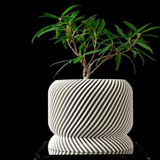 Stylish slant planter with black and white stripe pattern, ideal for home or office plant display.