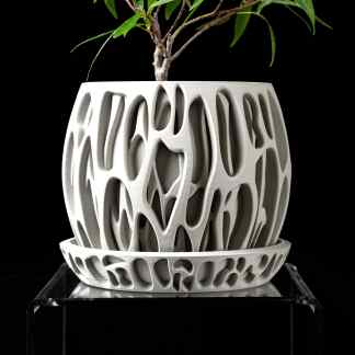Modern 3D-printed slime planter with artistic, intricate cutouts for stylish home decor.