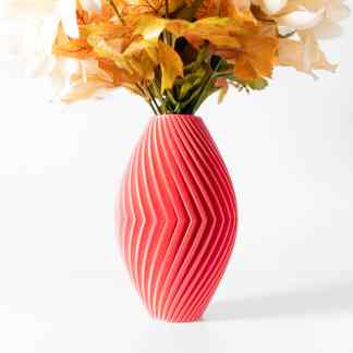 Close-up of a pink 3D printed vase featuring a textured, spiral pattern holding colorful artificial flowers.
