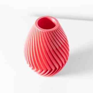 Vibrant pink 3D printed vase with intricate spiral design, showcasing advanced additive manufacturing technology.