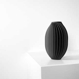 Black 3D-printed vase with ribbed design, minimalist style, displayed on a white surface.