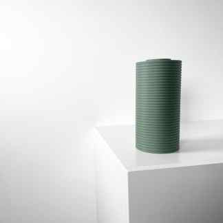 Elegant green 3D-printed vase displayed on white surface, showcasing contemporary material and smooth finish.