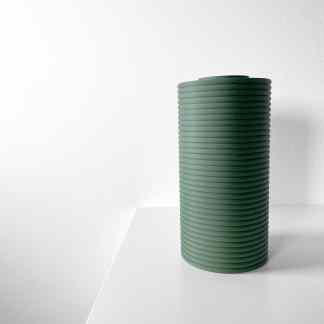 Low-angle view of a rolled green yoga mat on white background, eco-conscious fitness gear, environmentally friendly sports equipment.