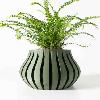 A sleek, modern 3D-printed plant pot featuring black stripes holding a lush fern plant.
