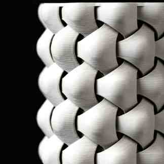 Detailed close-up of 3D printed white lattice pattern on black background.