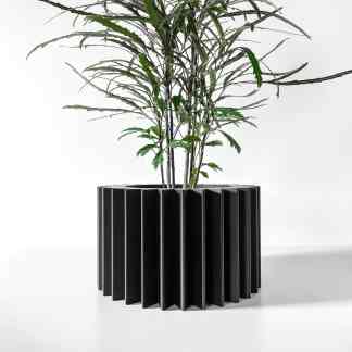 Stylish black 3D-printed planter with lush green houseplant, perfect for modern interiors.