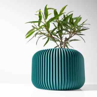 Stylish teal ceramic-like 3D printed vase with green plant, modern interior design.