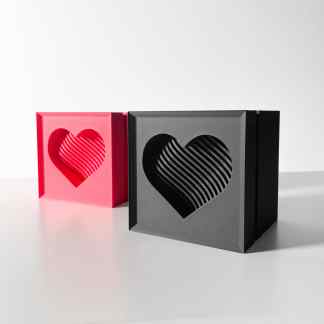 Colorful 3D printed heart-shaped boxes with intricate striped patterns, highlighting innovative 3D printing craftsmanship.