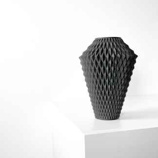 Modern black 3D-printed vase with intricate geometric design, displayed on white surface.