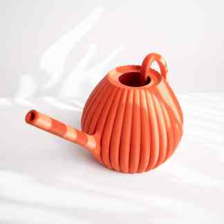 Bright orange 3D printed watering can with textured surface, eco-friendly design.