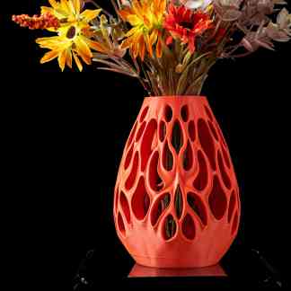 Colorful artificial floral arrangement in a modern, sculptural vase on black background.