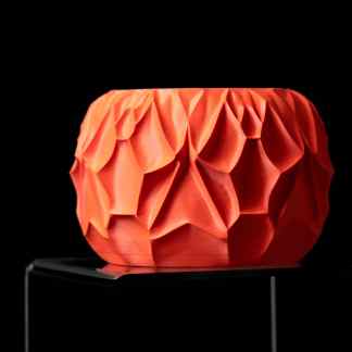Colorful 3D printed geometric sculpture with intricate faceted design on black background.