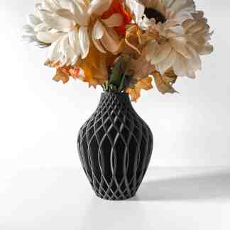 Black geometric 3D printed vase with floral arrangement.