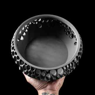 Black and white 3D-printed object with intricate honeycomb design and textured surface.