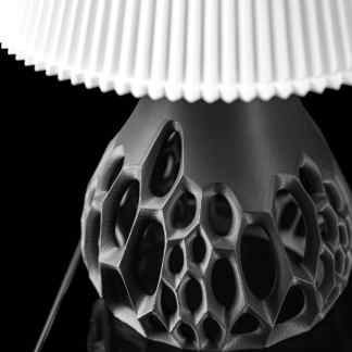 Elegant black-and-white close-up of a modern, intricately designed 3D printed lamp base.