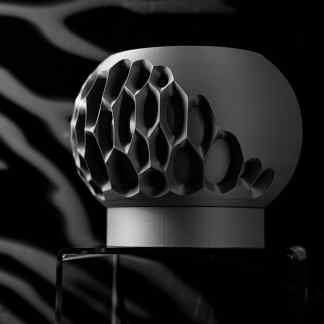 A detailed black and white image of an advanced 3D-printed ventilator component showcasing complex honeycomb design.
