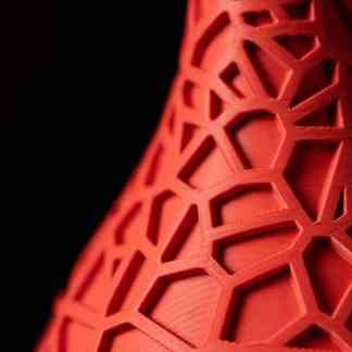 Detailed red 3D printed geometric lattice pattern, modern and artistic design.