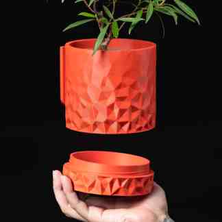 Bright orange geometric pattern 3D-printed plant holder, perfect for stylish home or office plant display.