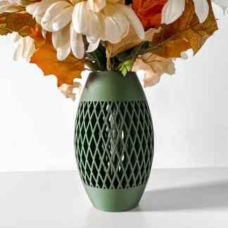Elegant green vase with intricate lattice design holding autumn-colored flowers and leaves.