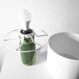 Close-up of a sleek, energy-efficient LED bulb with green heat sink design on a white background.