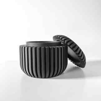 High-resolution black and white image of a modern, sleek gear-inspired container with removable lid.