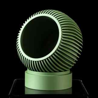 Close-up of a modern, green 3D-printed geometric art sculpture with ribbed design, displayed on black background.