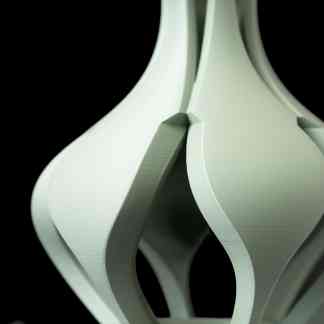 Detailed close-up of a white 3D printed decorative object with artistic curves.
