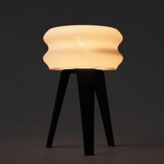 Stylish 3D-printed lamp with unique curved shade on wooden tripod stand for modern decor.