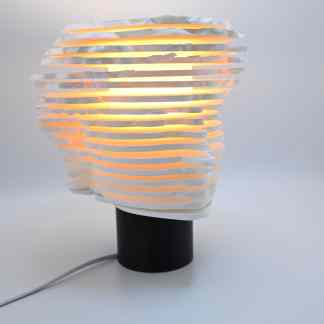 Illuminated 3D-printed lampshade with layered paper effect, perfect for stylish home decor and ambient lighting.