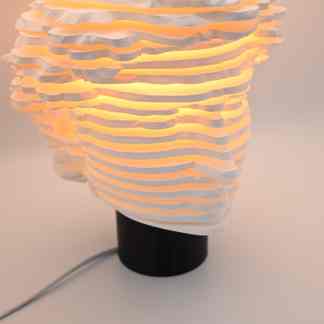 Unique modern lamp with layered paper-like shades and warm ambient light.